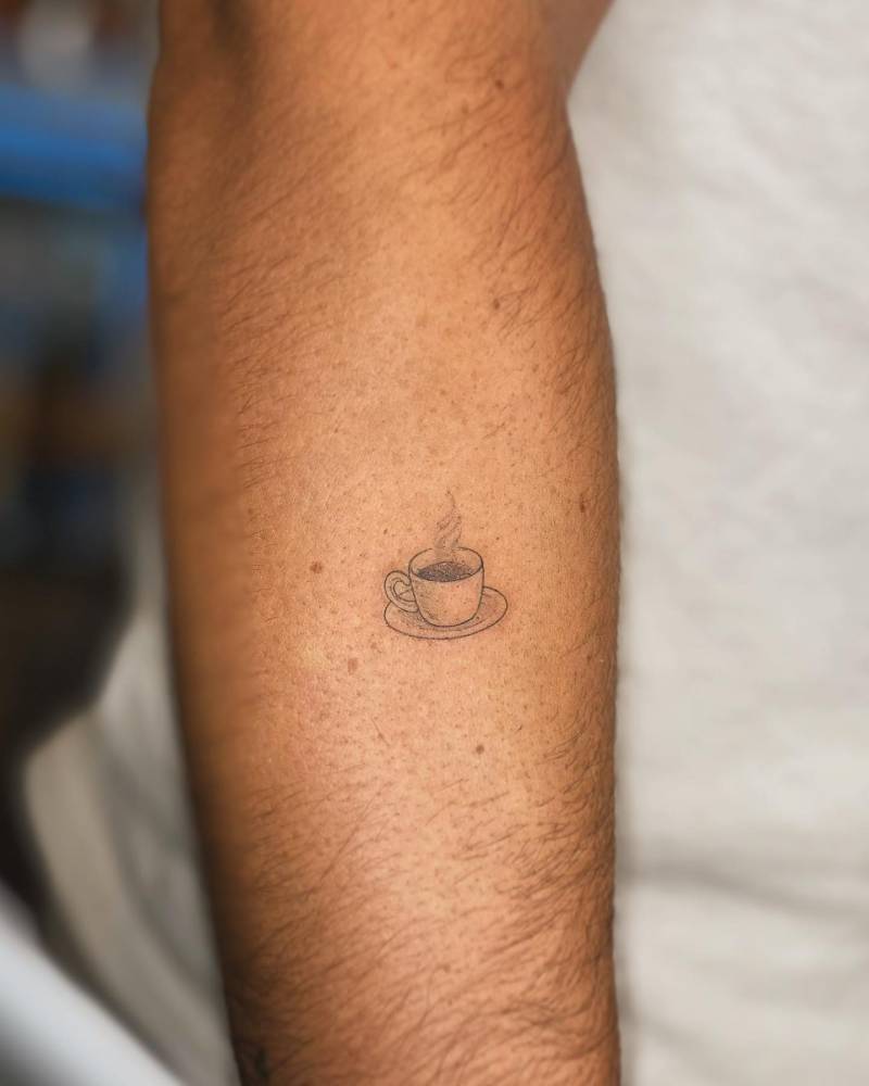 Minimalistic style coffee cup tattoo placed on the forearm.