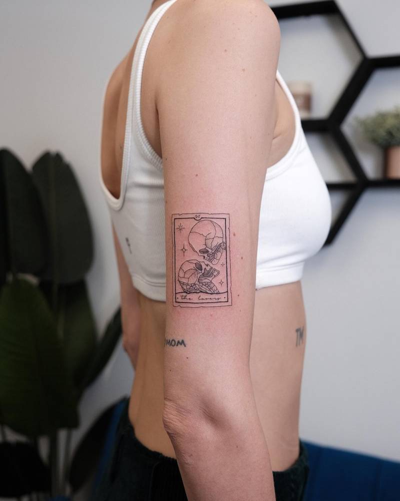 The lovers tarot card tattoo located on the upper arm.