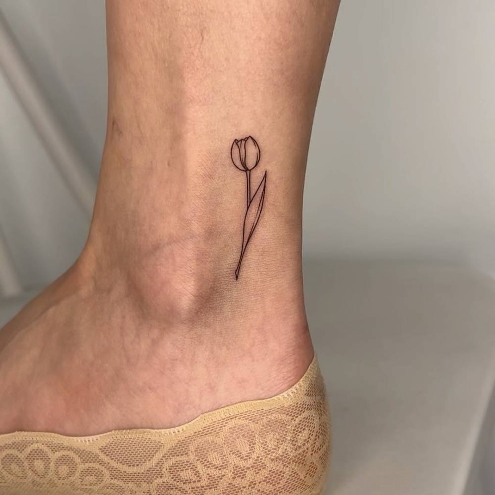 Tulip tattoo done on the ankle, fine line style.