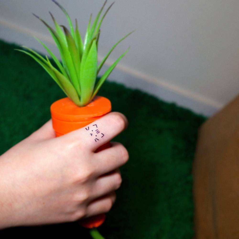 Cute minimalistic cat tattoo located on the finger.