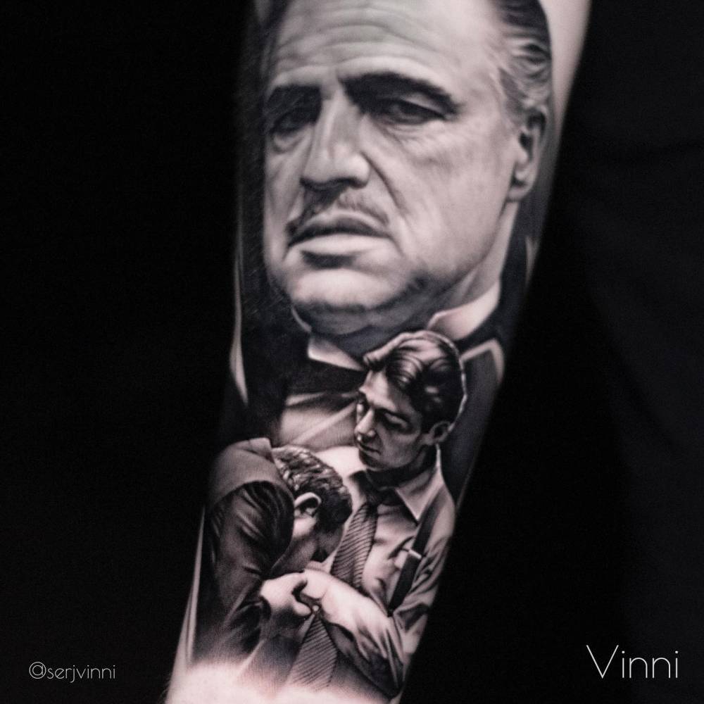 Godfather themed tattoo located on the inner forearm, black and grey style.