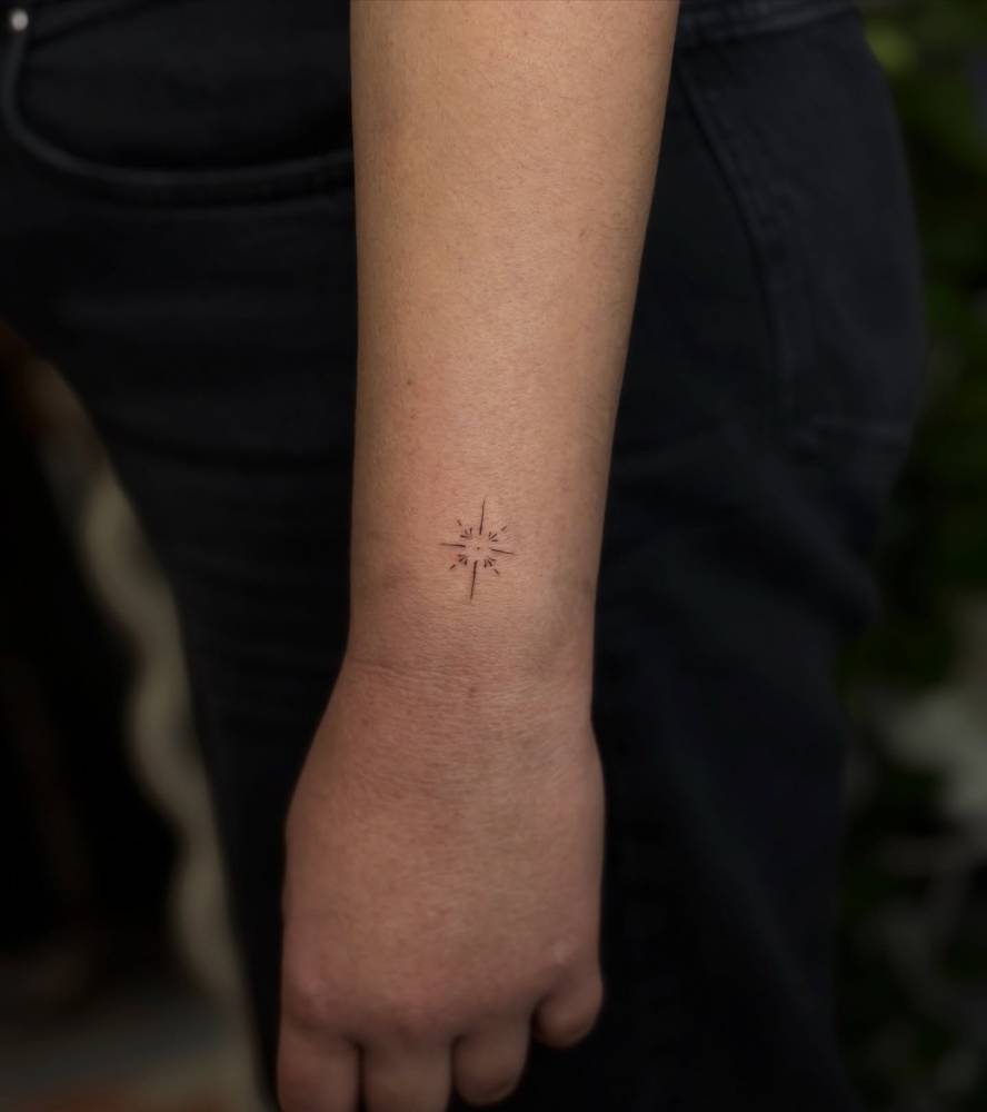 Tiny minimalistic ornament tattoo placed on the wrist.