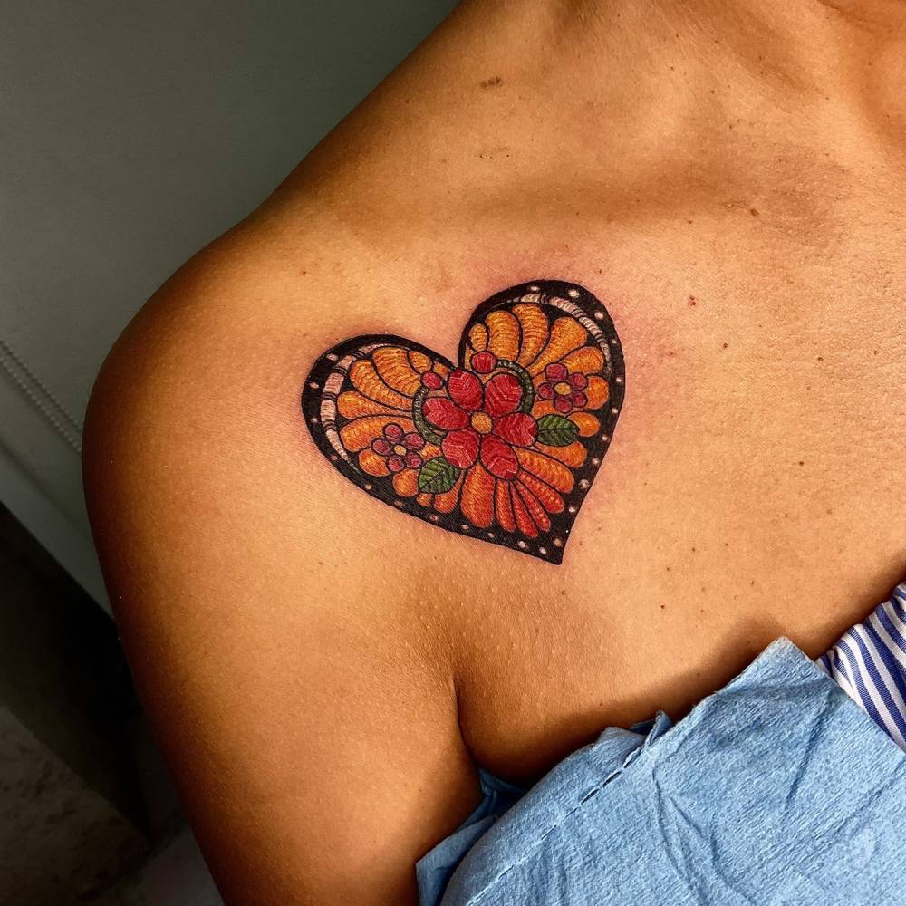 Mexican embroidery heart tattoo located on the shoulder.