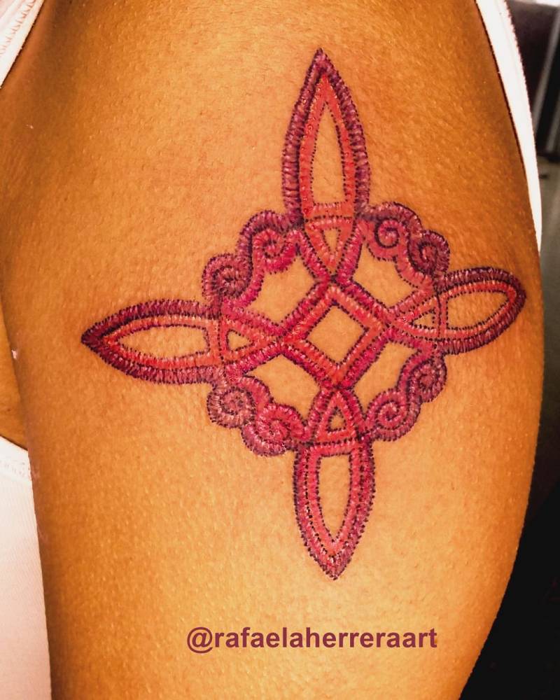 Celtic quaternary knot tattoo in embroidery style located on the upper arm.