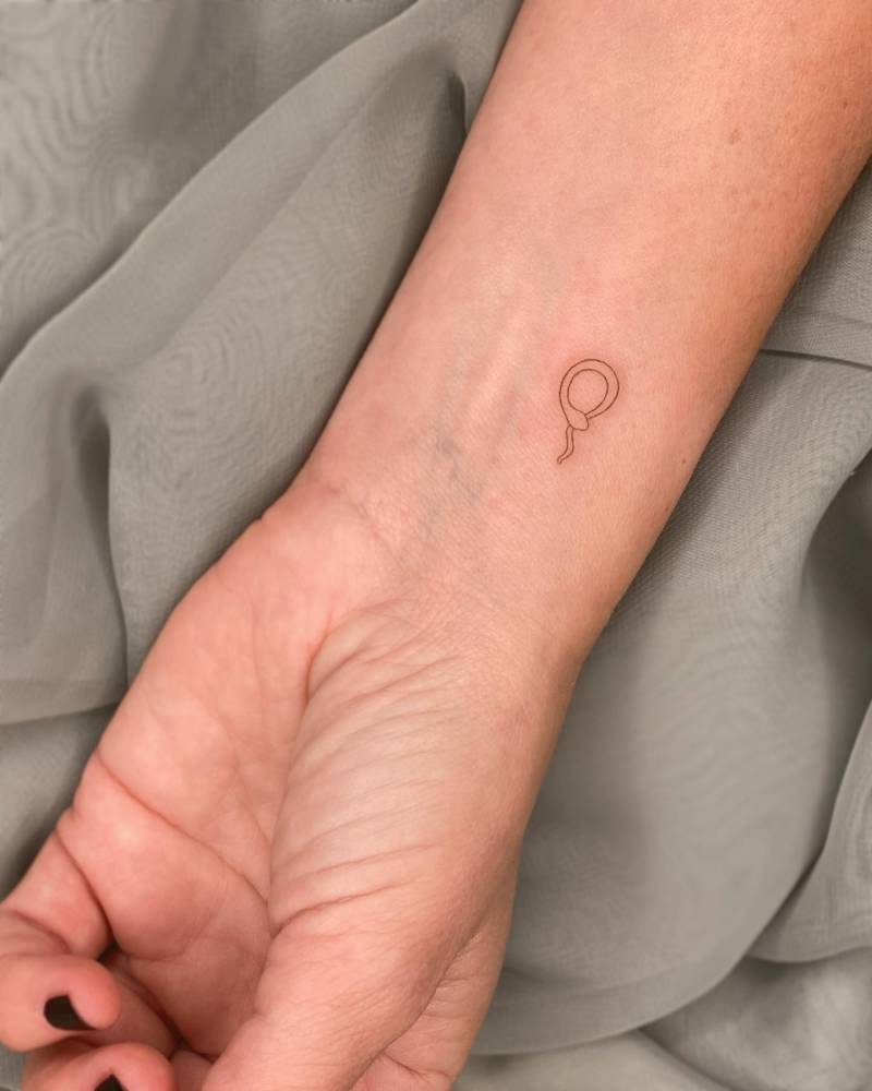 Minimalistic little snake tattoo located on the wrist.