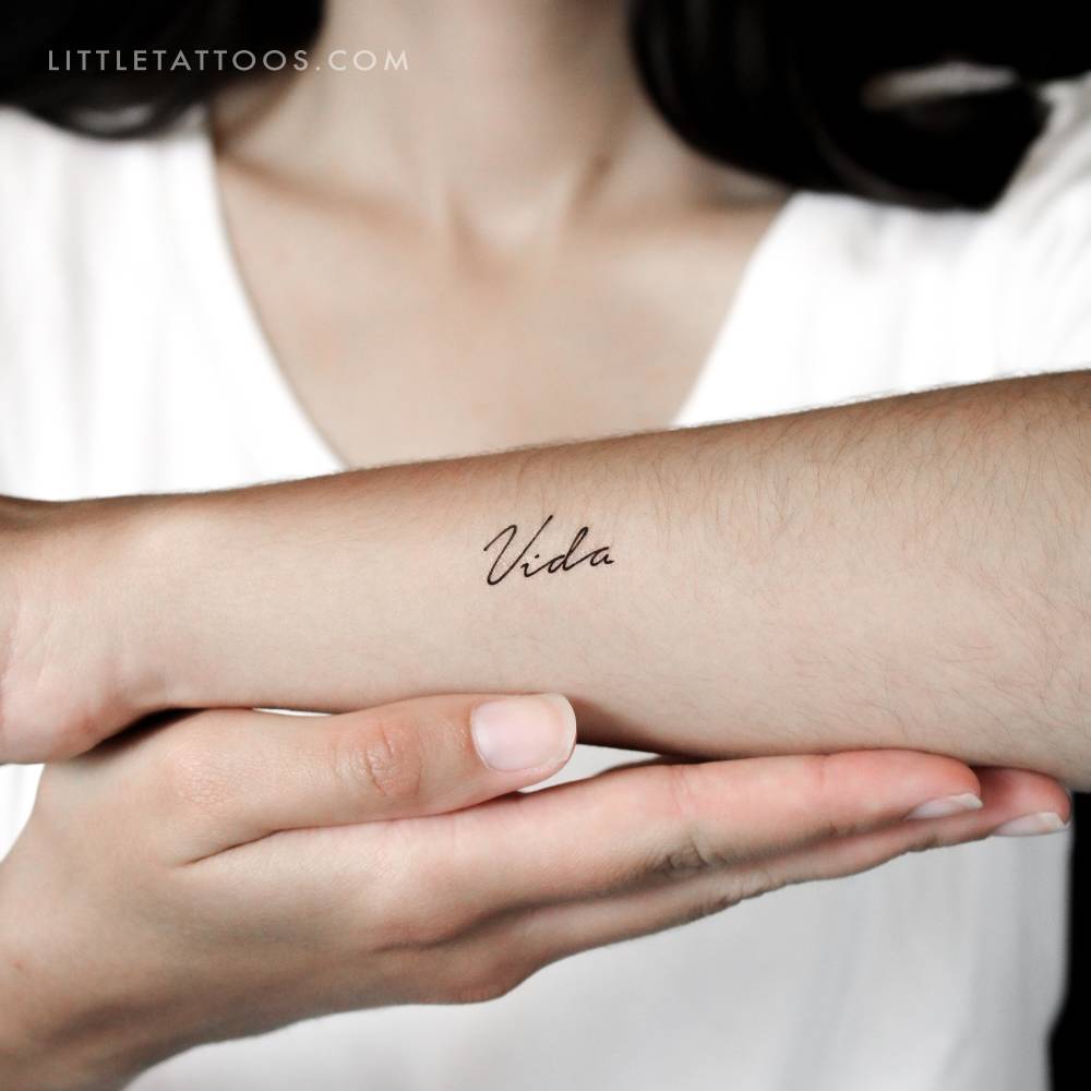 Word "vida" temporary lettering tattoo located on the wrist.