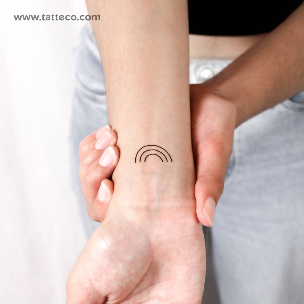 Minimal rainbow temporary tattoo located on the wrist.