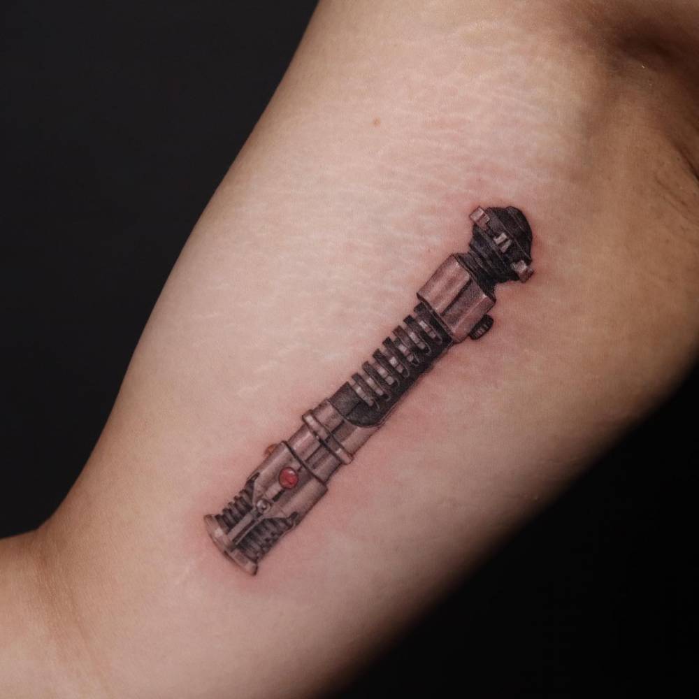 Obi Wan Kenobi’s Lightsaber tattooed on the inner arm.