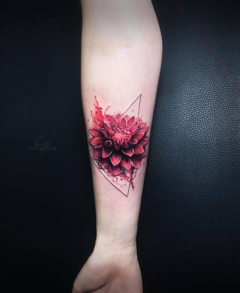 Realistic style dahlia tattoo placed on the inner forearm.