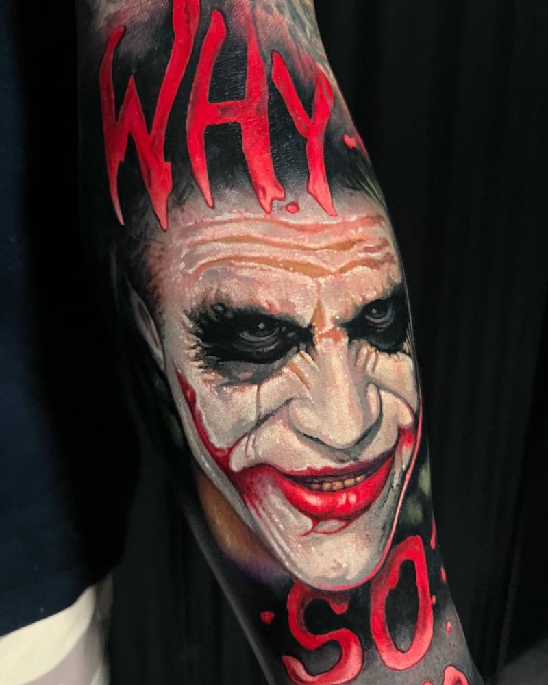 Joker portrait tattoo in realistic style located on the inner forearm.
