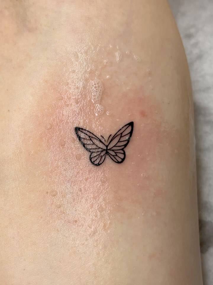Fine line style butterfly tattoo placed on the inner forearm.