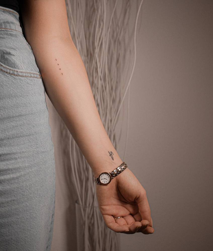 Number 1602 tattoo located on the inner forearm.