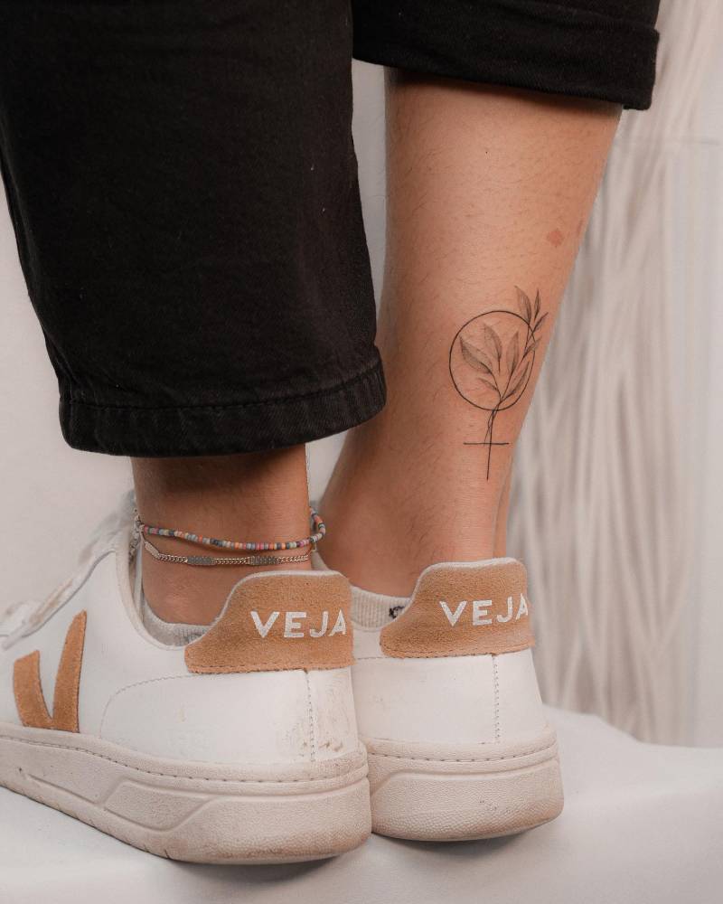 Venus symbol and leaves tattoo done on the achilles.