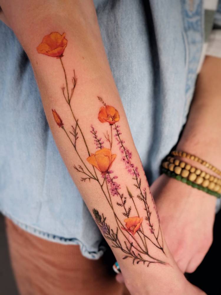 Realistic style California poppy tattoo located on the forearm.