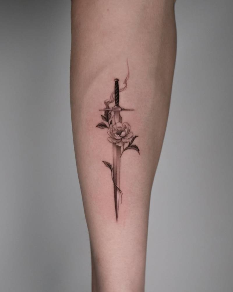 Rose and sword tattoo located on the inner forearm, micro-realistic style.