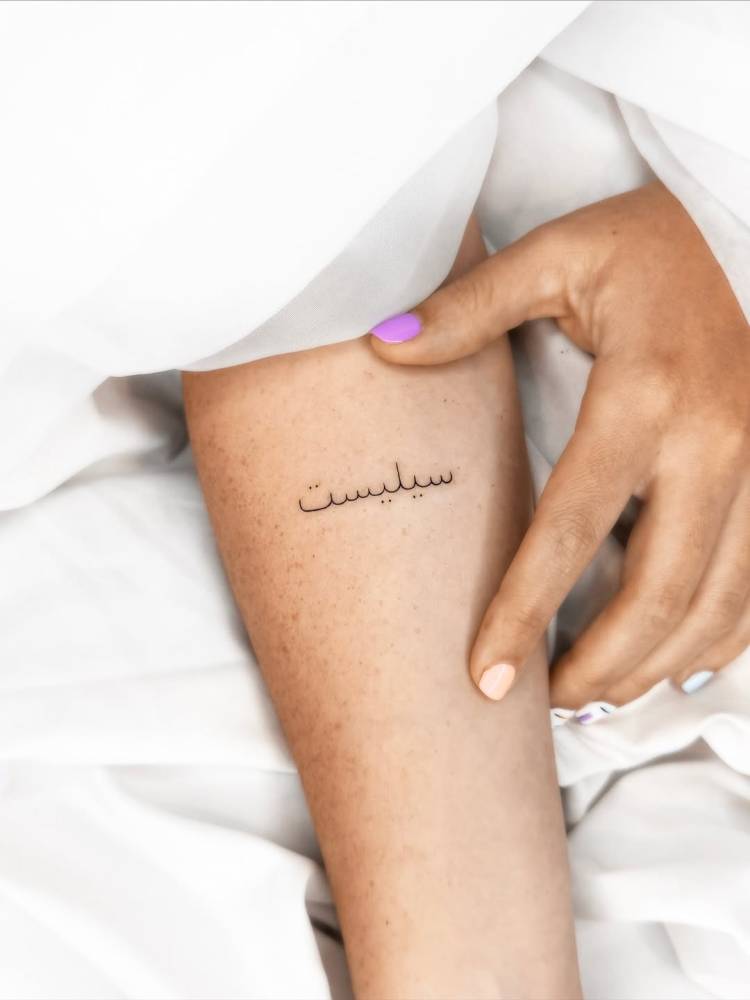Arabic lettering tattoo located on the inner forearm.