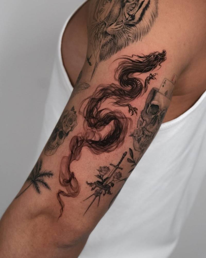 Dragon tattoo in illustrative style done on the upper arm.