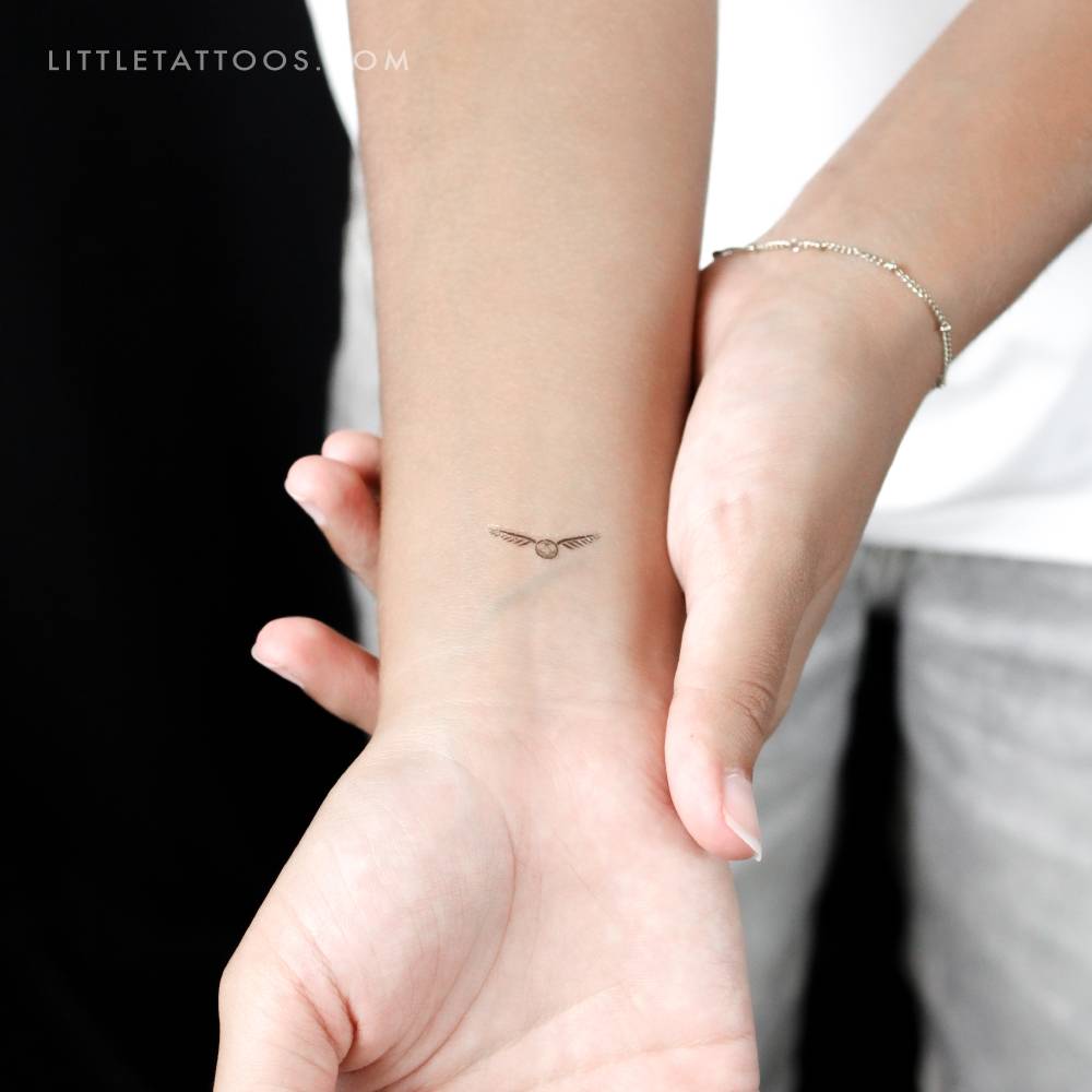 Golden snitch temporary tattoo located on the wrist.