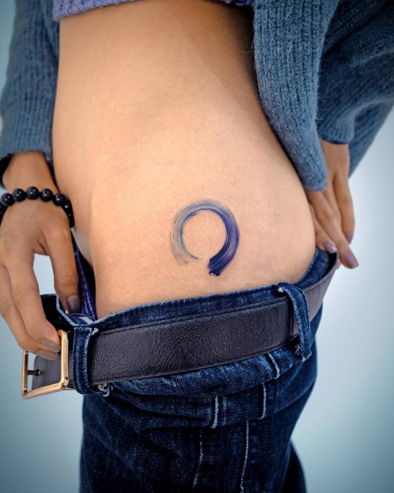 Ensō tattoo in watercolor style located on the hip.