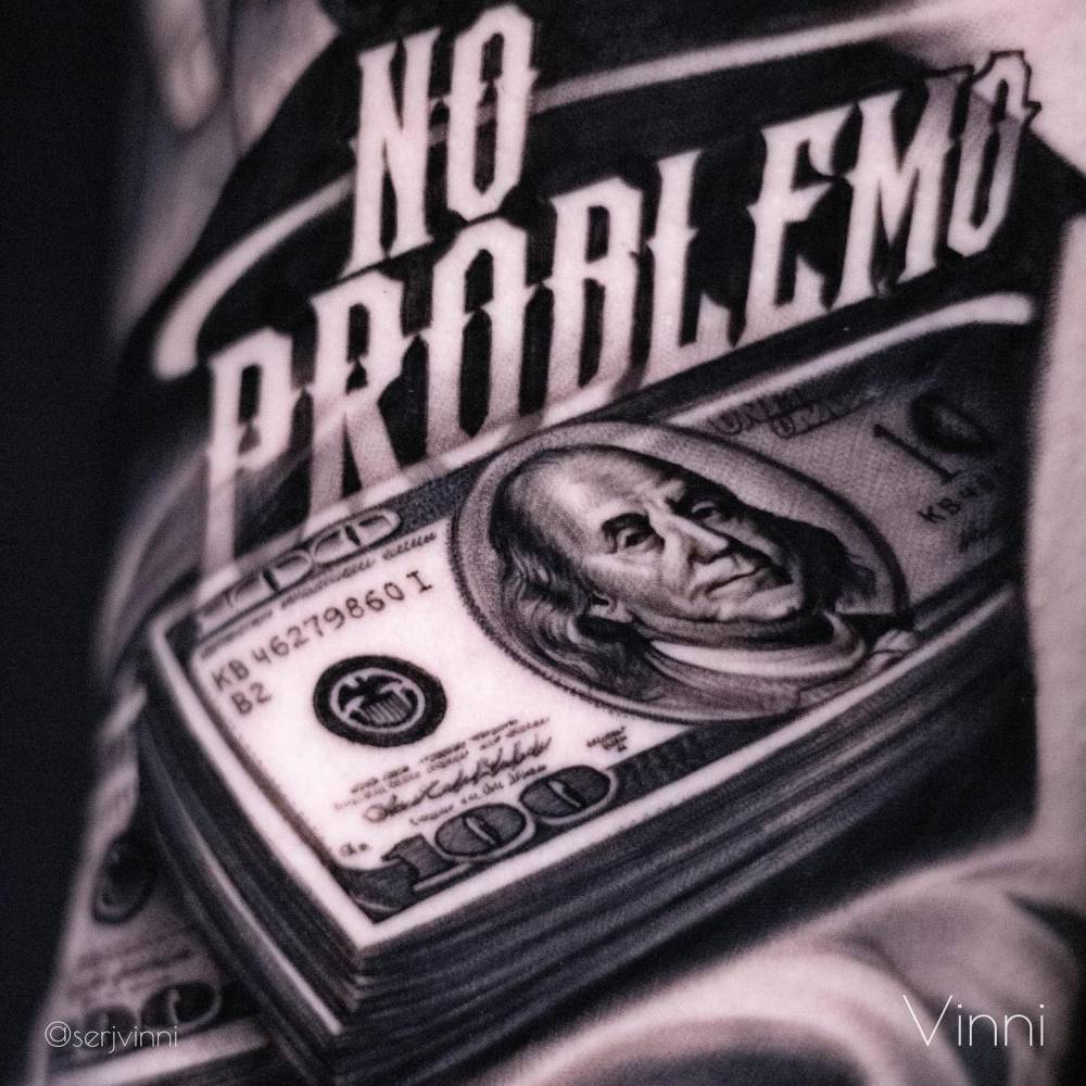 Dollar bills tattooed on the upper arm.