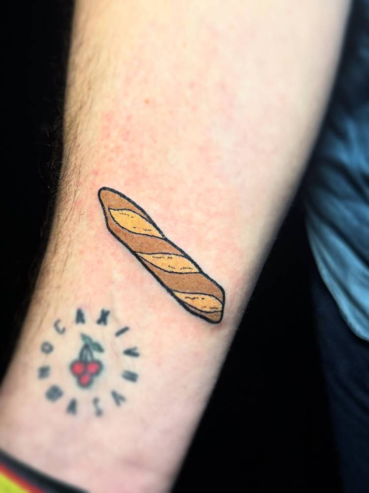 Hand poked style baguette tattoo located on the wrist.