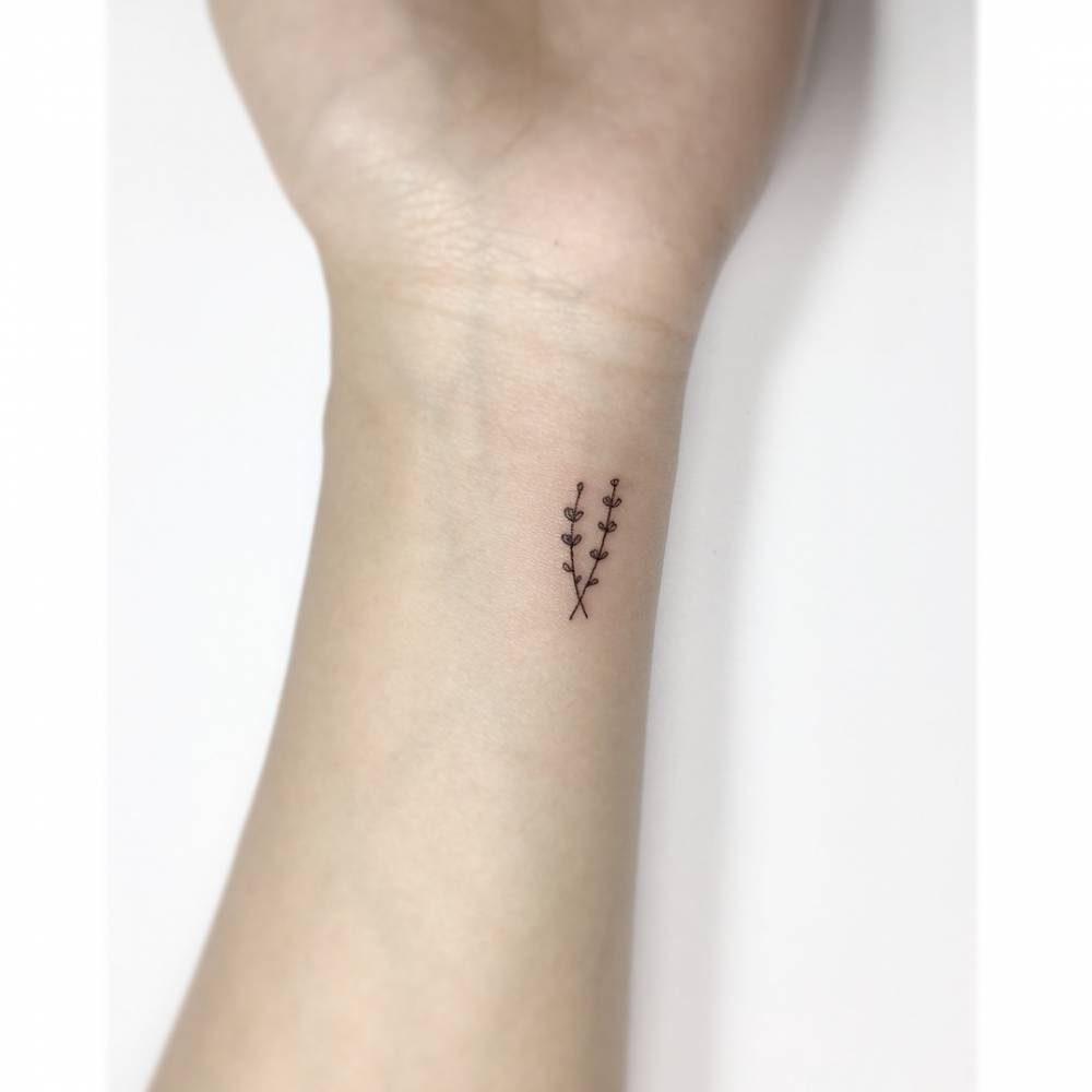 Tiny minimalistic lavender tattoo located on the wrist.