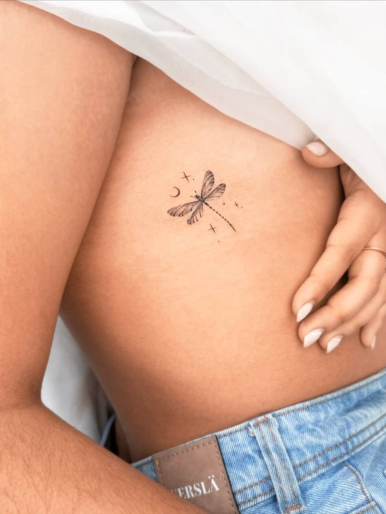 Dragonfly tattoo in micro-realistic style located on the rib.