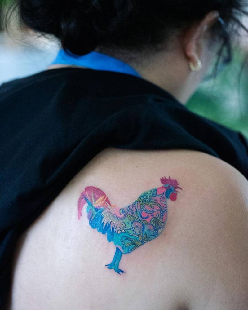 Rooster tattoo located on the shoulder blade.