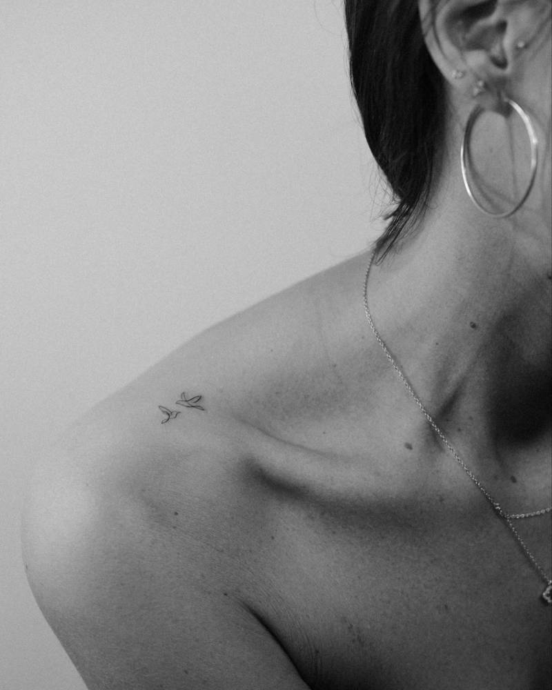 Minimalistic style flying birds tattoo located on the top of shoulder.
