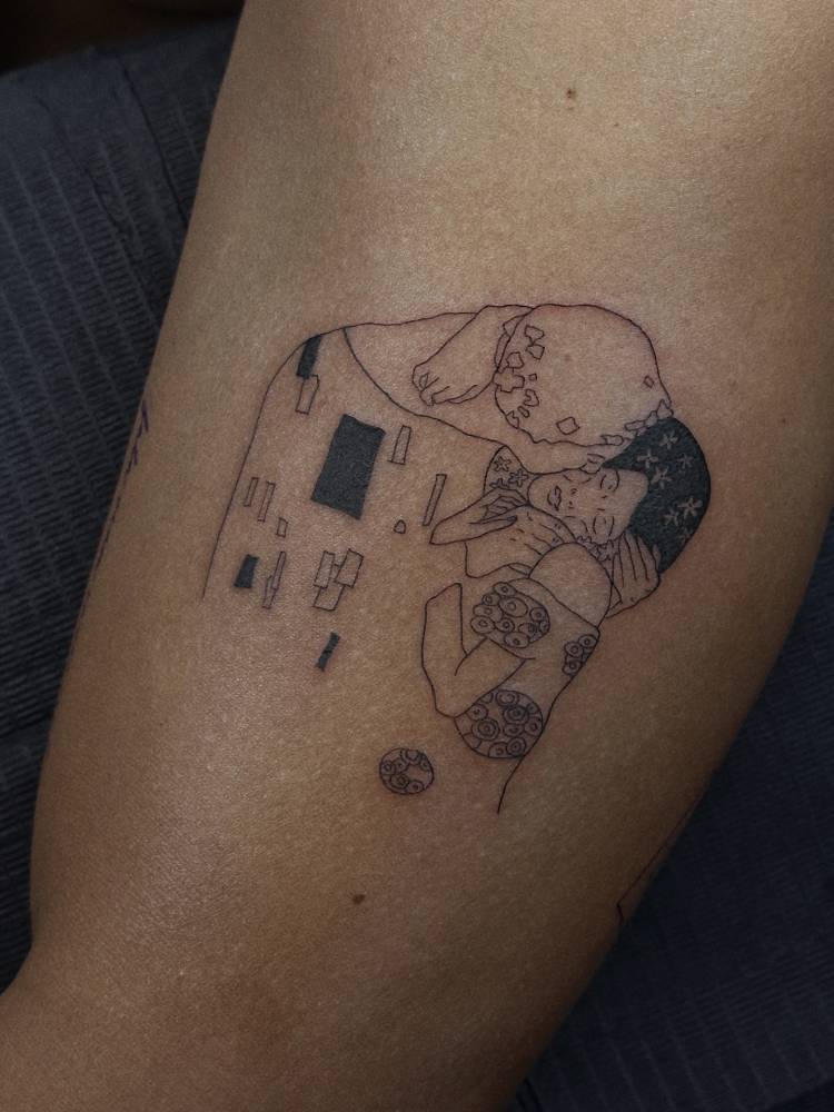 Klimt's 'The Kiss' tattoo located on the upper arm.