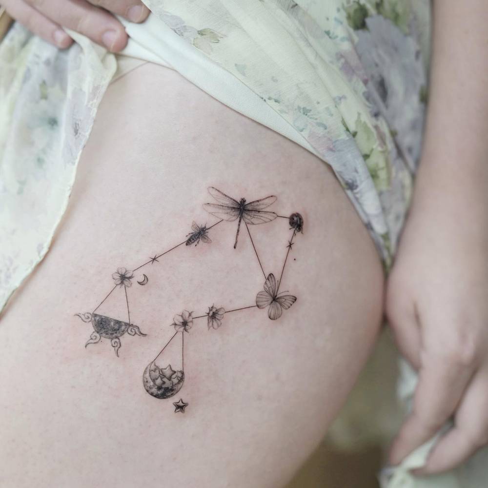 Libra constellation tattoo located on the thigh, illustrative style.