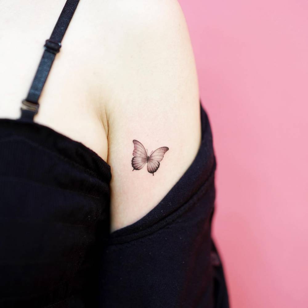Tattoo of a butterfly done in illustrative style, located on the tricep.