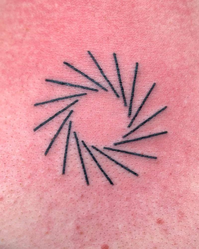 Line art sun tattoo done on the upper back.