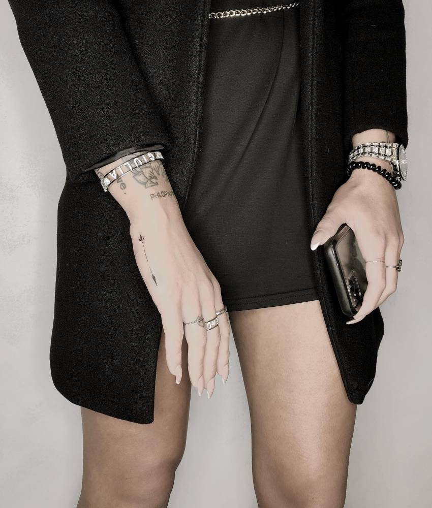 Minimalistic arrow tattoo located on the hand.