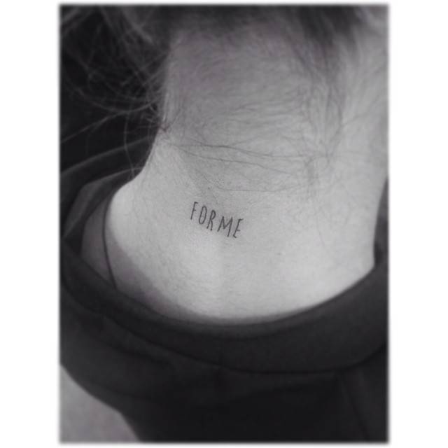 Tattoo of the word "forme" located on the back of the neck.