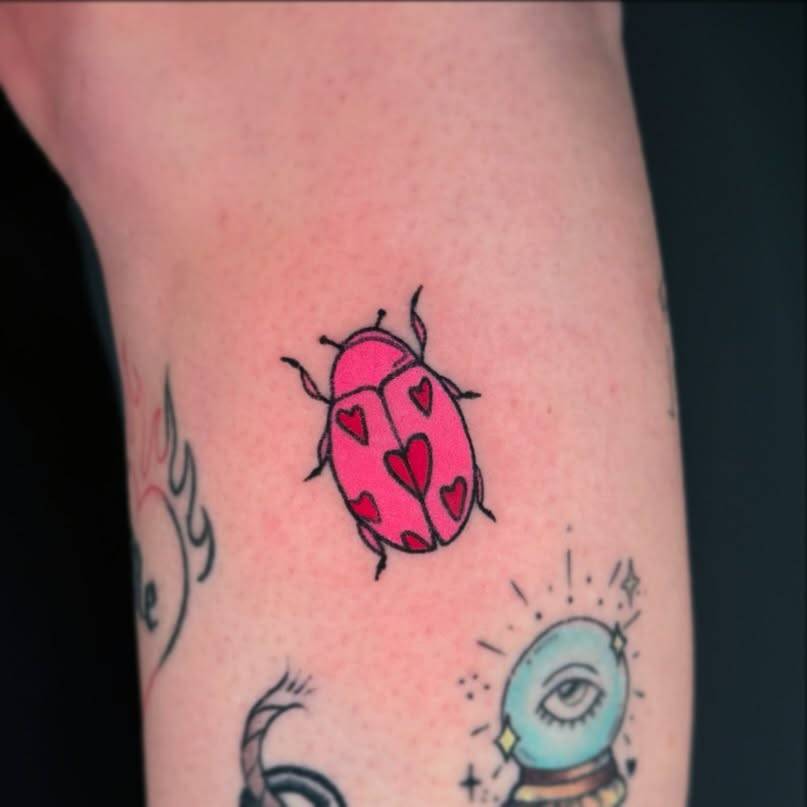 Hand poked ladybug tattoo in cartoon style located on the calf.