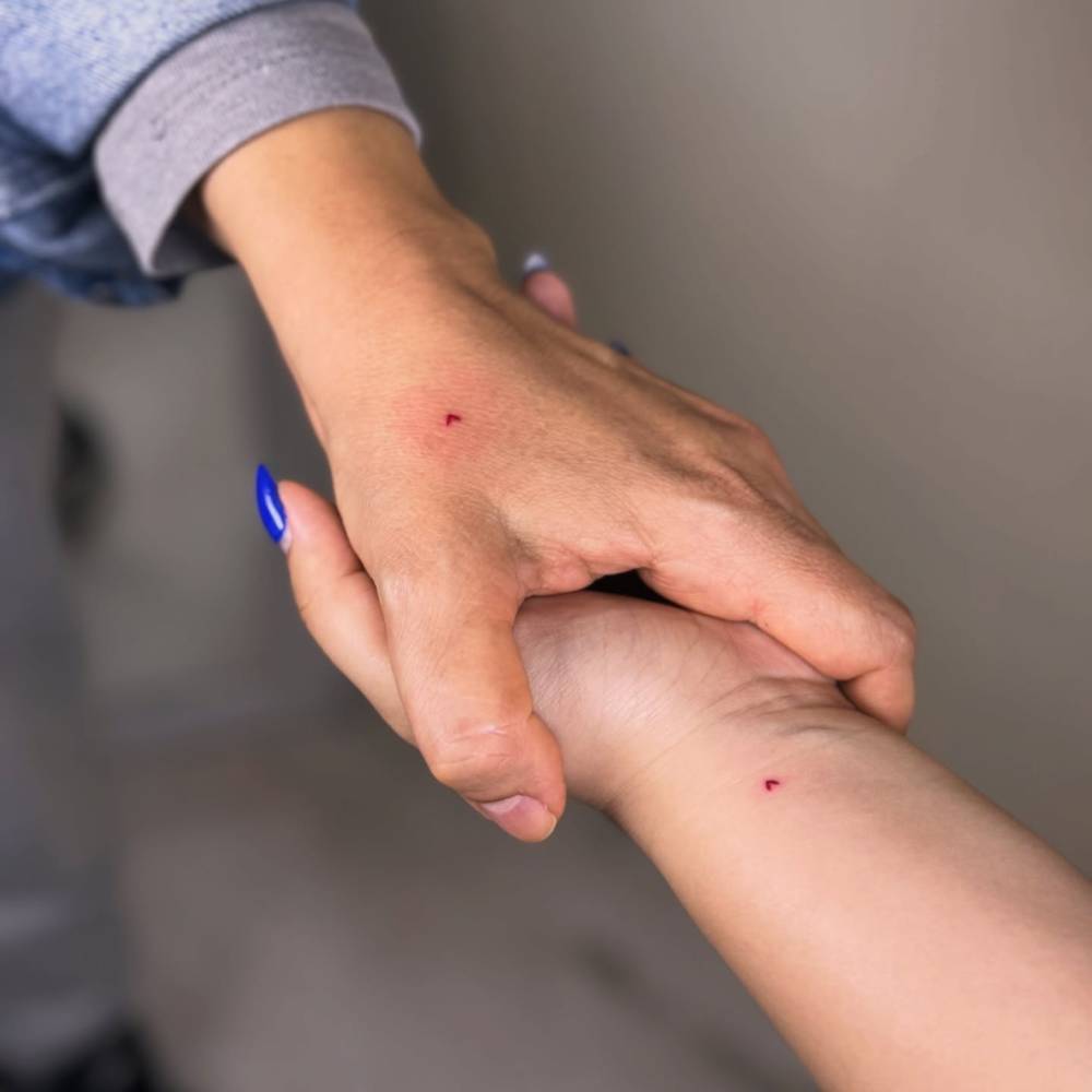 Matching tiny red heart tattoo in minimalistic style for best friends.