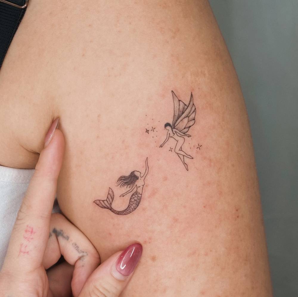 Illustrative style mermaid and fairy tattoo done on the upper arm.