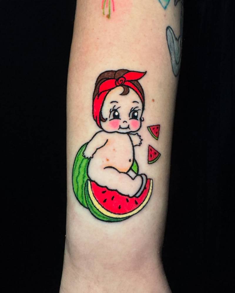 Watermelon kewpie tattoo located on the wrist, cartoon style.