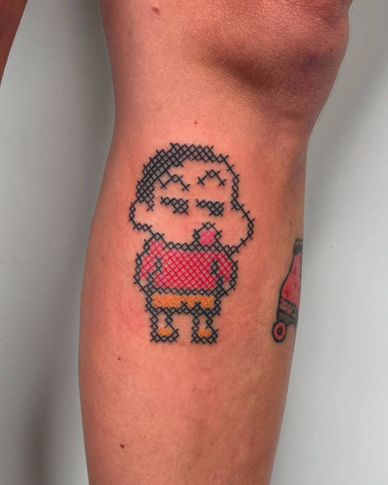 Cross stitch Shin-Chan tattoo located on the calf.