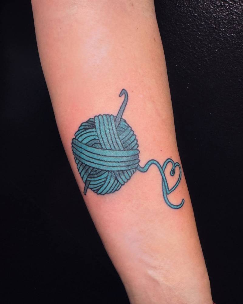 Hand poked wool yarn tattoo located on the inner forearm.
