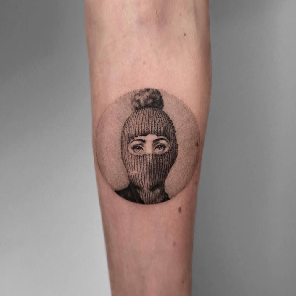 Fornasetti Tema e Variazioni 160 tattooed on the inner forearm.
