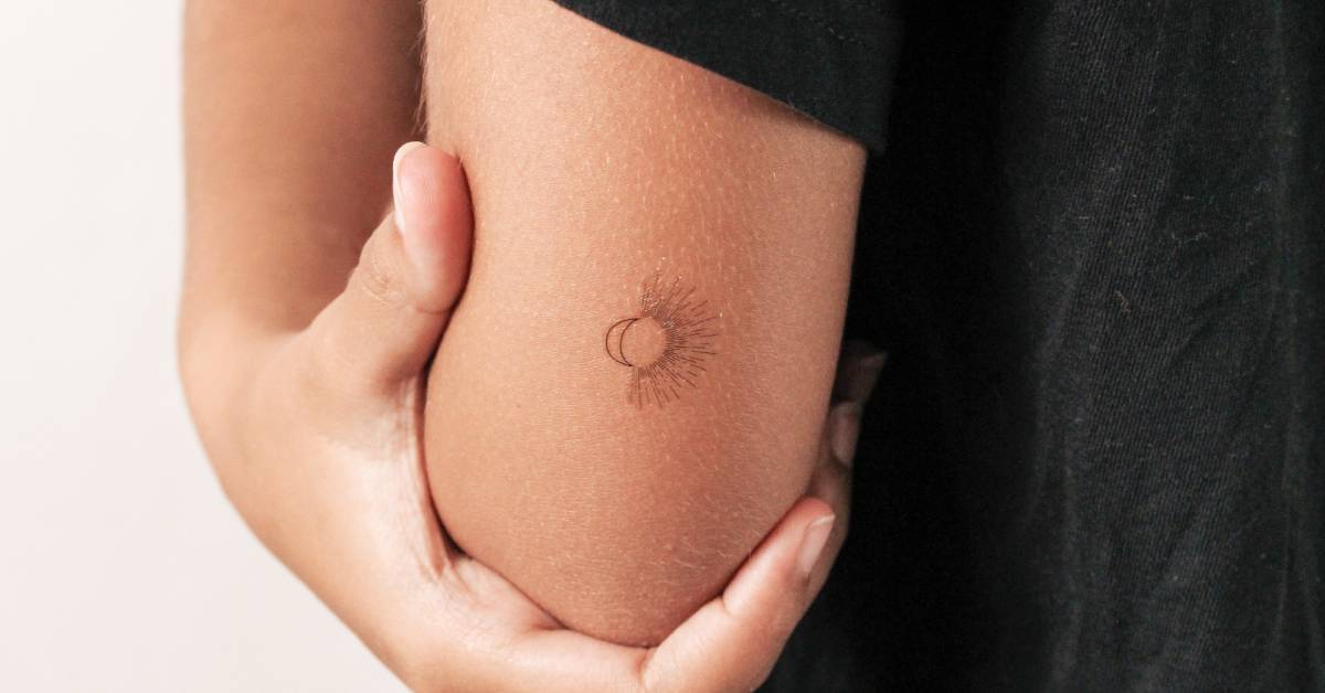 Fine line style sun + moon temporary tattoo located on