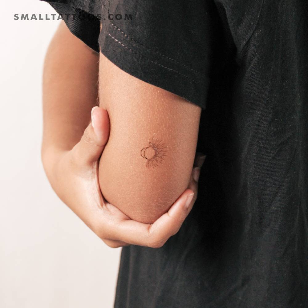 Fine line style sun + moon temporary tattoo located on the tricep.
