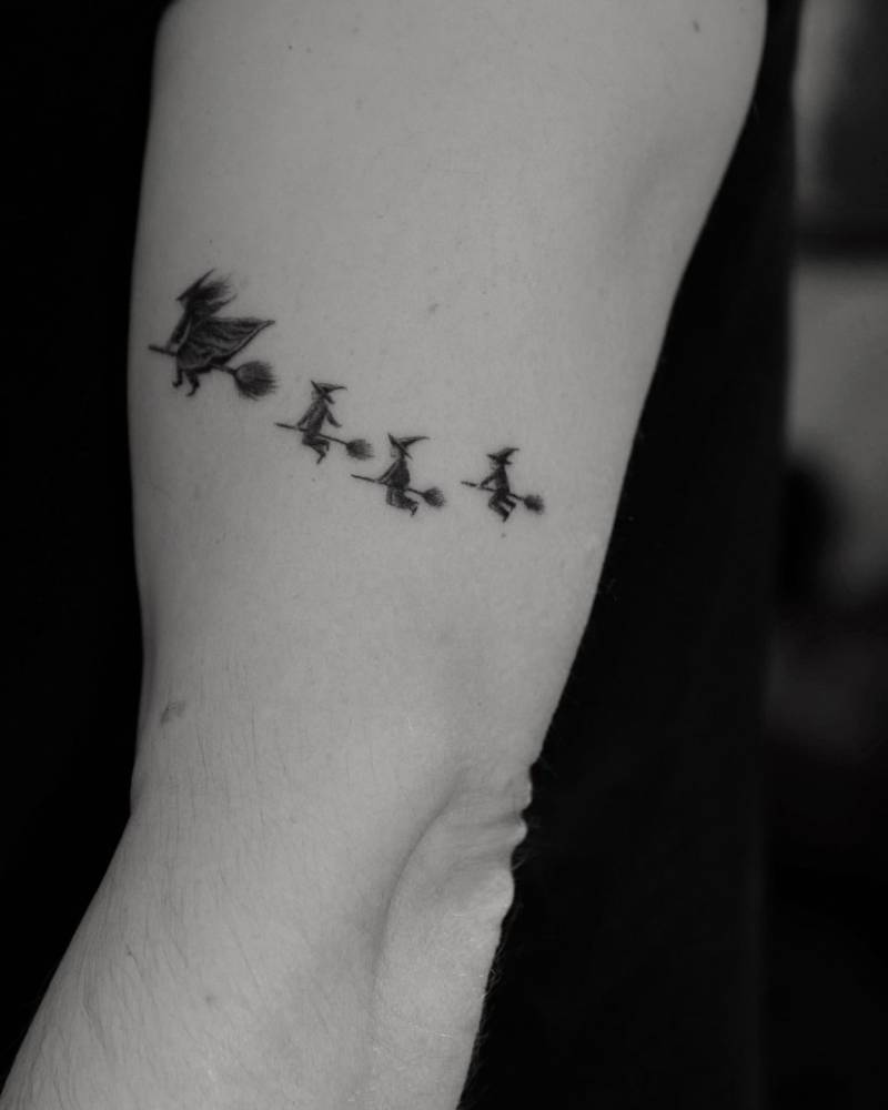 Single needle witches tattoo located on the upper arm.