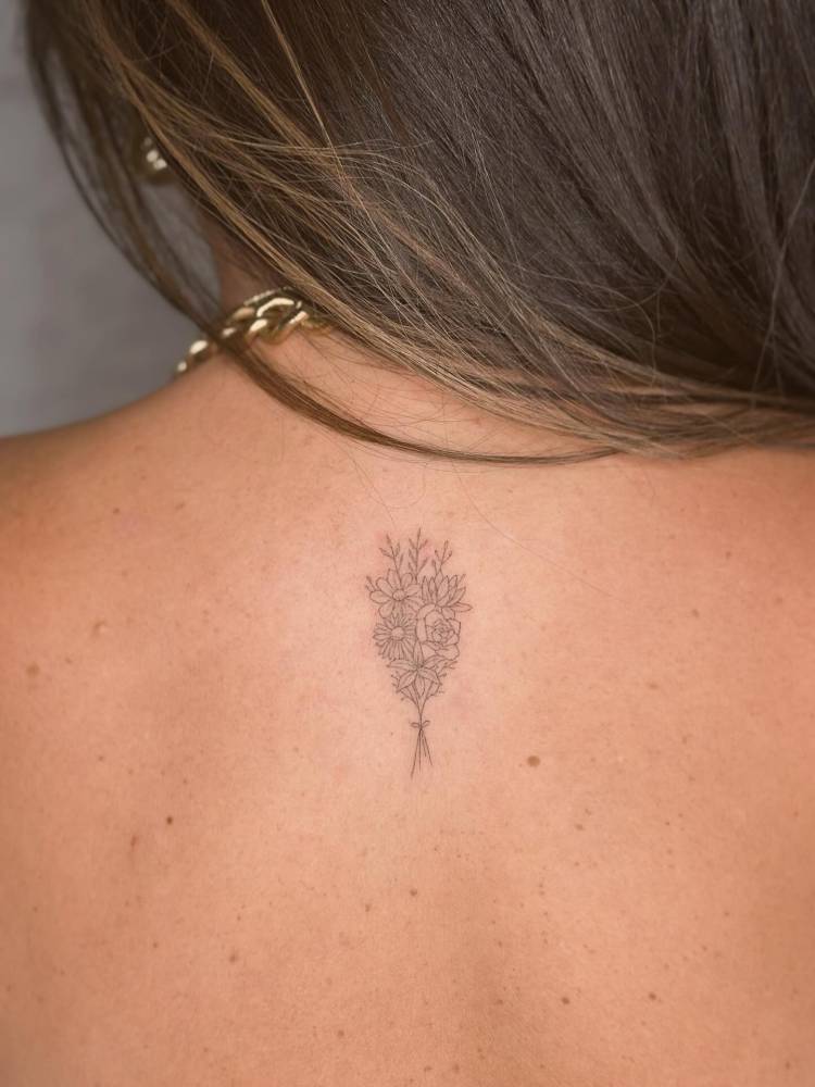 Flower bouquet tattoo done on the upper back, fine line style.
