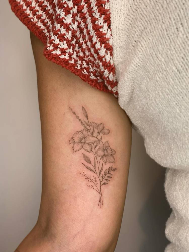 Illustrative style flower bouquet tattoo placed on the inner arm.