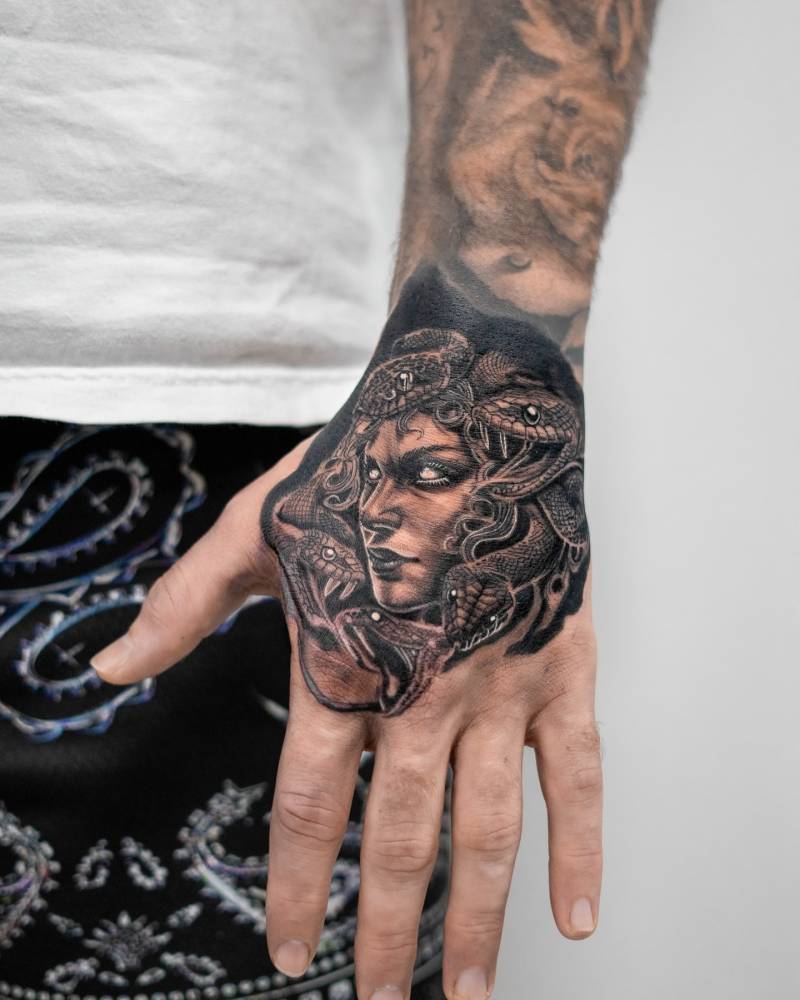 Medusa portrait tattoo in illustrative style done on the hand.