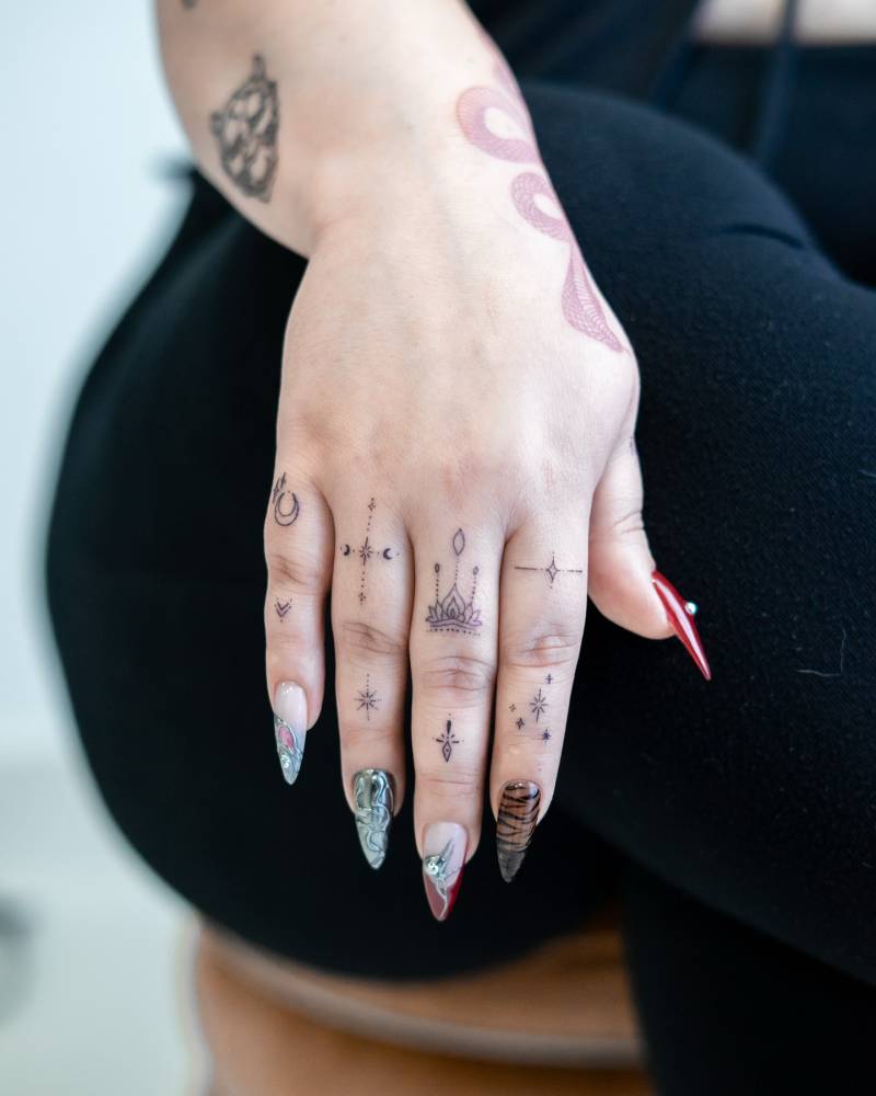 Fine line style ornamental finger composition tattoos.