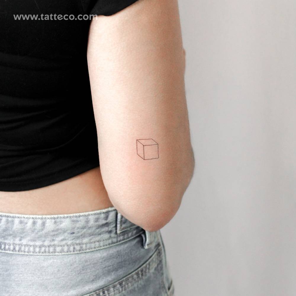 Little cube temporary tattoo located on the tricep.